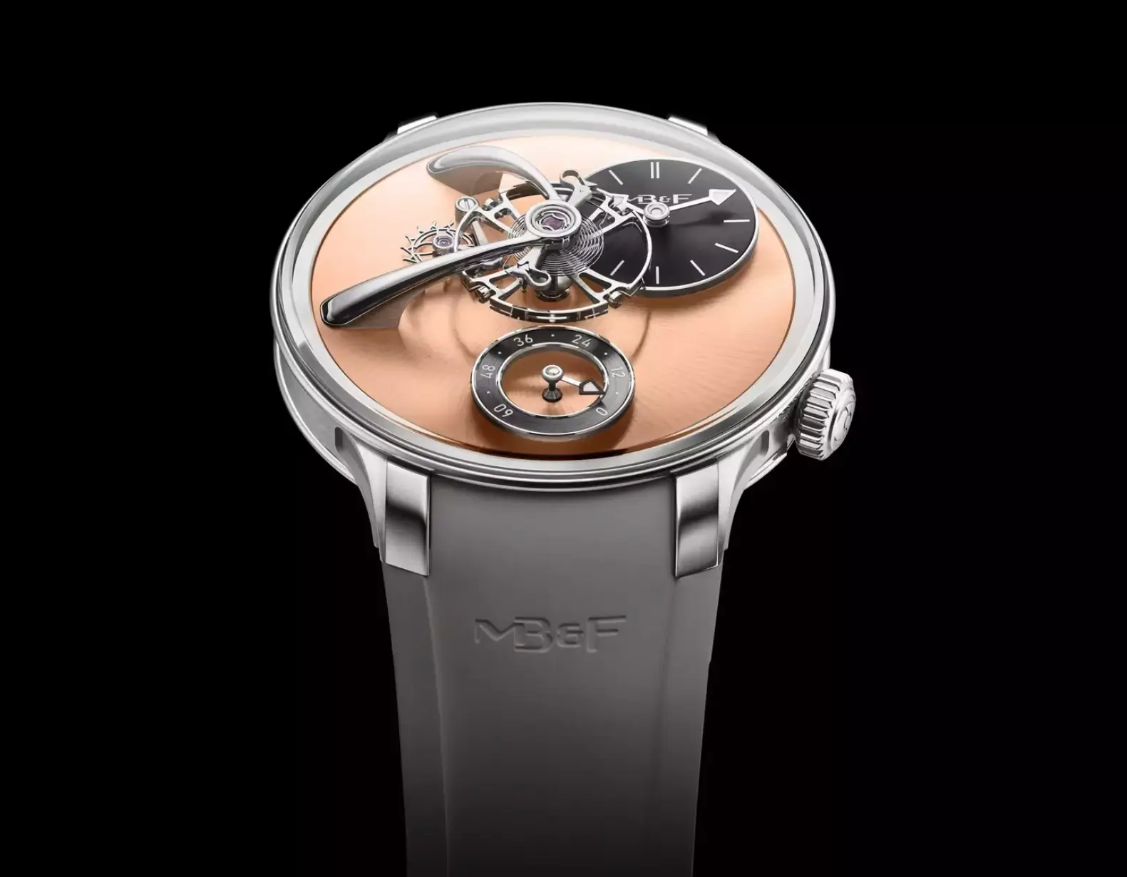 MB&F wristwatch with a salmon dial, exposed balance wheel, black time display, and gray rubber strap.
