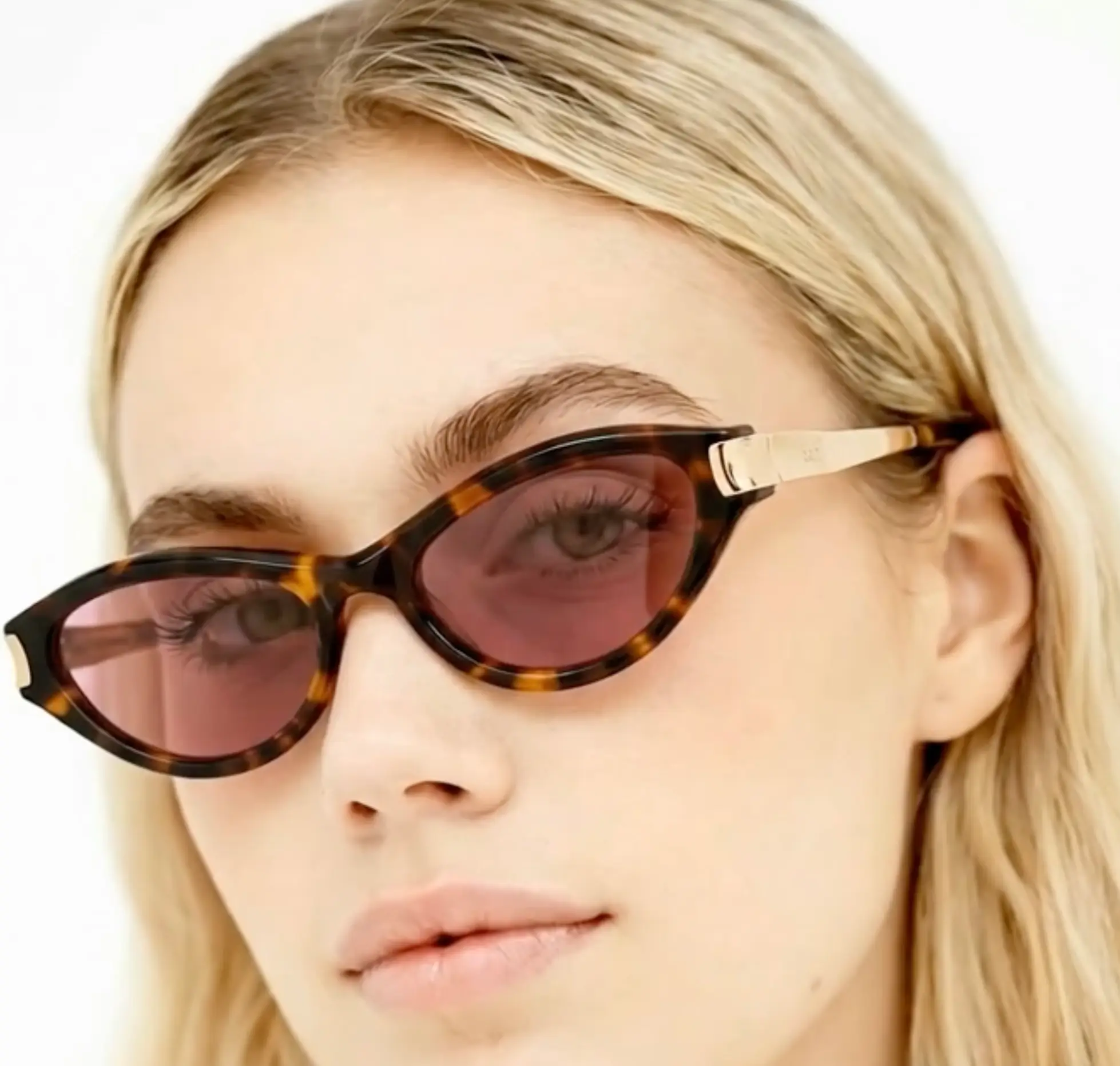 Model wearing RSF Blades Series 2026 cat-eye sunglasses in tortoiseshell acetate with rose-tinted lenses and polished gold-tone temples, shown in a close-up portrait.