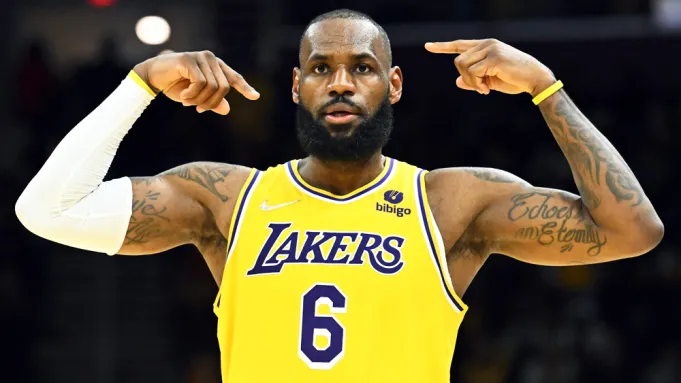 LeBron James in Lakers jersey pointing to his head