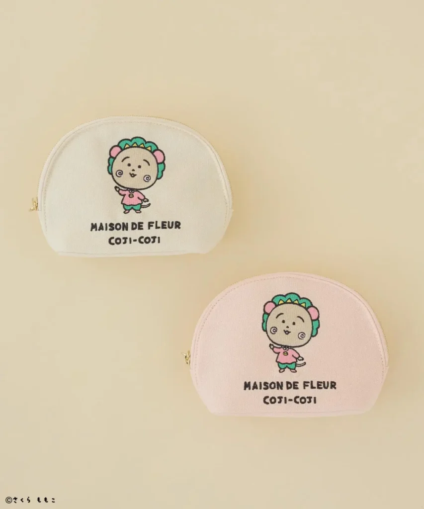 Two embroidered Maison de FLEUR coin purses, one cream and one pink, feature a cartoon character and text
