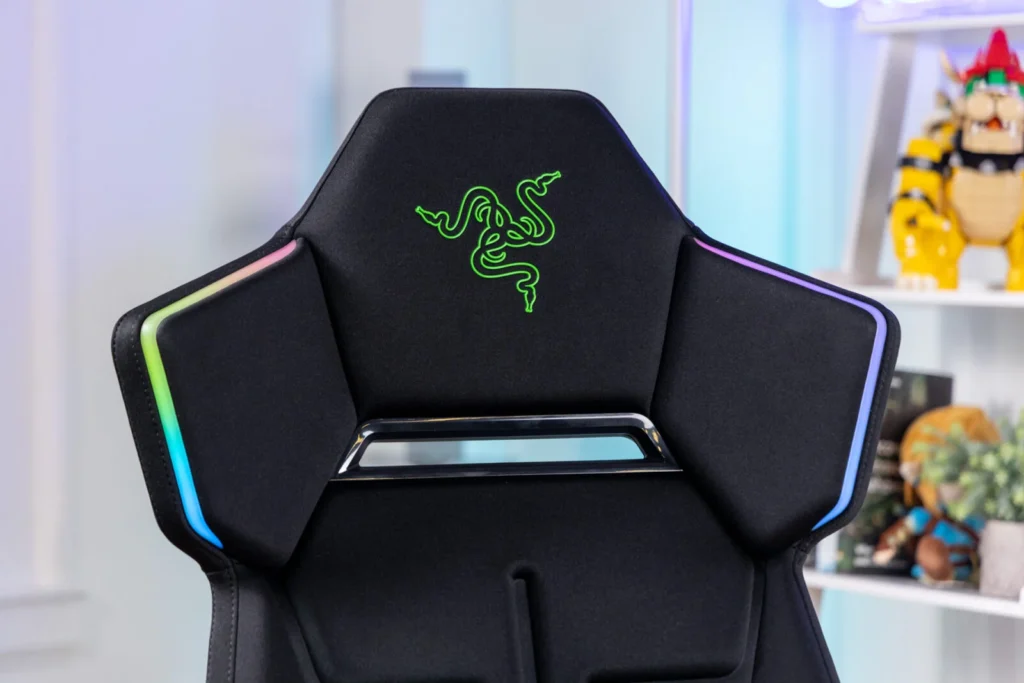 Close up view of Razer gaming chair highlighting the embroidered green Razer logo and RGB Chroma lighting along the shoulder panel