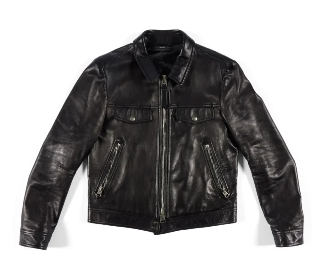 Front view of a black Tom Ford leather trucker-style jacket with a pointed collar, silver front zipper, two snap-flap chest pockets, angled zip hand pockets, and a fitted sil in smooth leather.