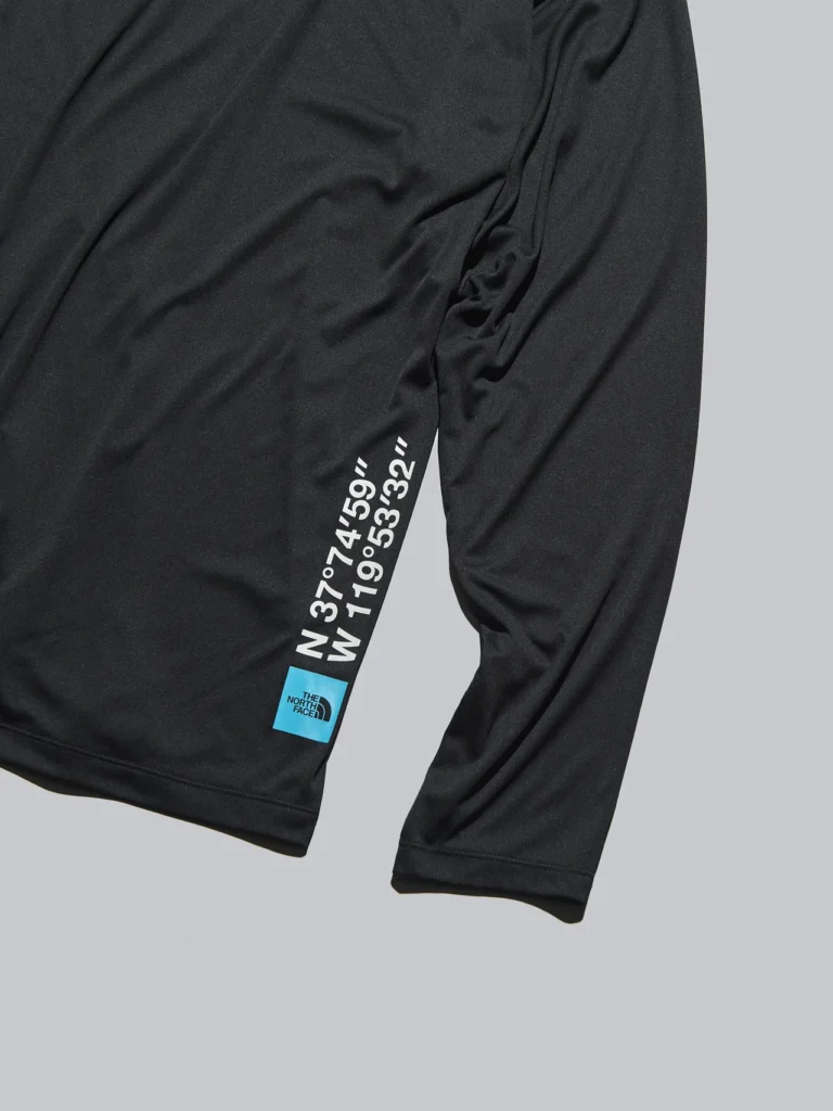 Close-up of the shirt’s lower side showing vertical white coordinates and a small blue The North Face label