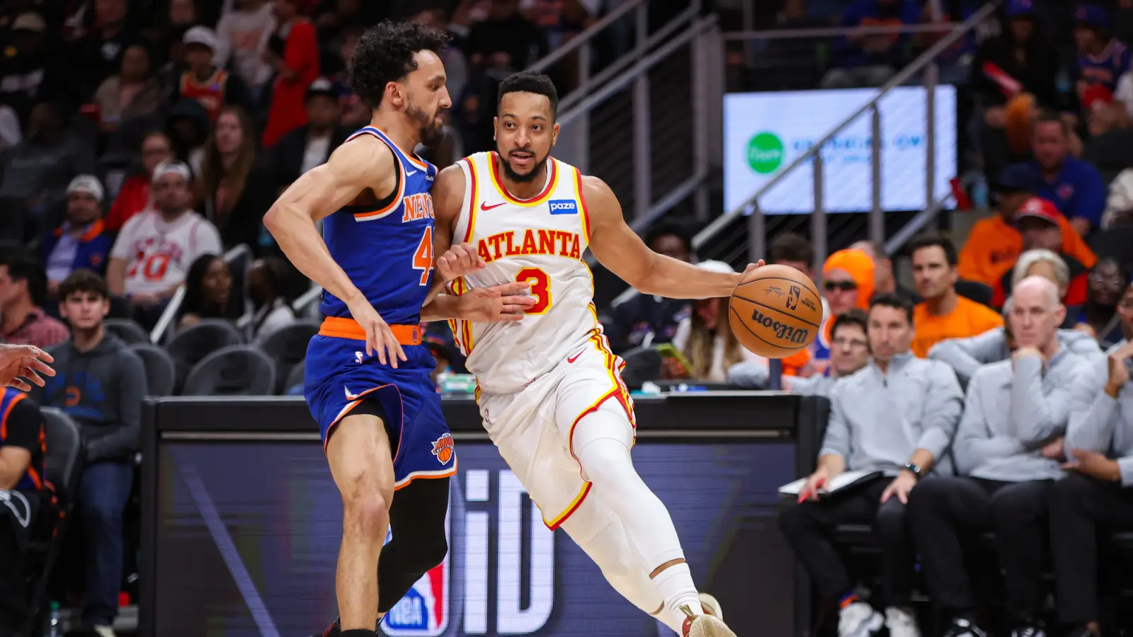 Atlanta Hawks guard dribbles past a New York Knicks defender during an NBA game at State Farm Arena.