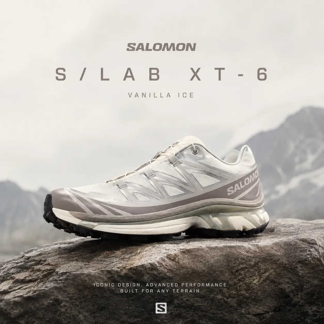 Promotional image of the Salomon S/LAB XT-6 'Vanilla Ice' trail running shoe resting on a rugged rock against a soft alpine mountain backdrop. The cream, silver, and light taupe colorway is highlighted with subtle natural lighting, while the Quicklace system, layered mesh upper, and sculpted outsole emphasize the shoe's blend of technical trail performance and modern lifestyle appeal.