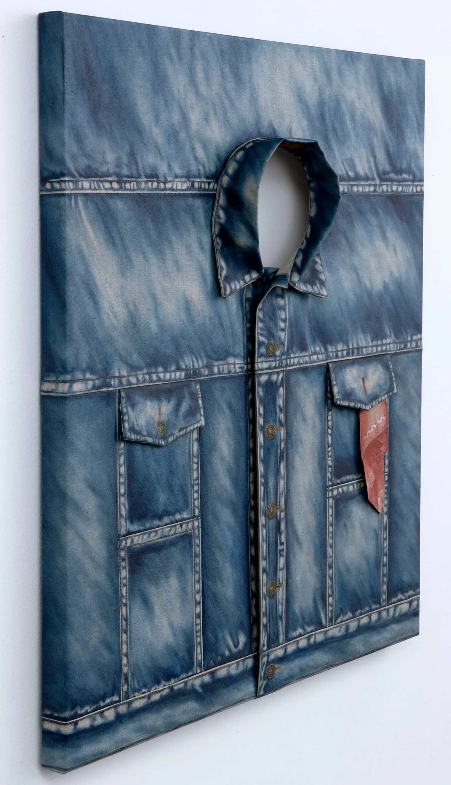 Three-dimensional sewn painting depicting a faded blue denim jacket with realistic stitching, chest pockets, metal buttons, and an open collar mounted on a stretched canvas.