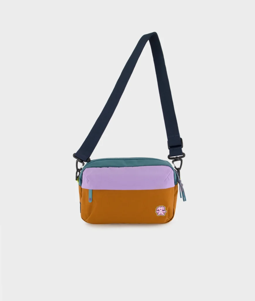 Compact Crumpler crossbody bag in camel, lavender, and teal color blocking shown against a clean white background with an adjustable shoulder strap