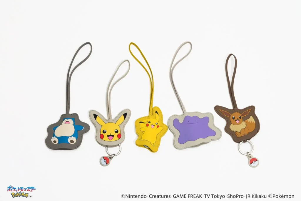 Five leather Pokémon luggage tags shaped like Snorlax, Pikachu, Pikachu in motion, Ditto, and Eevee, each with a matching strap and small Poké Ball charm, arranged on a white background