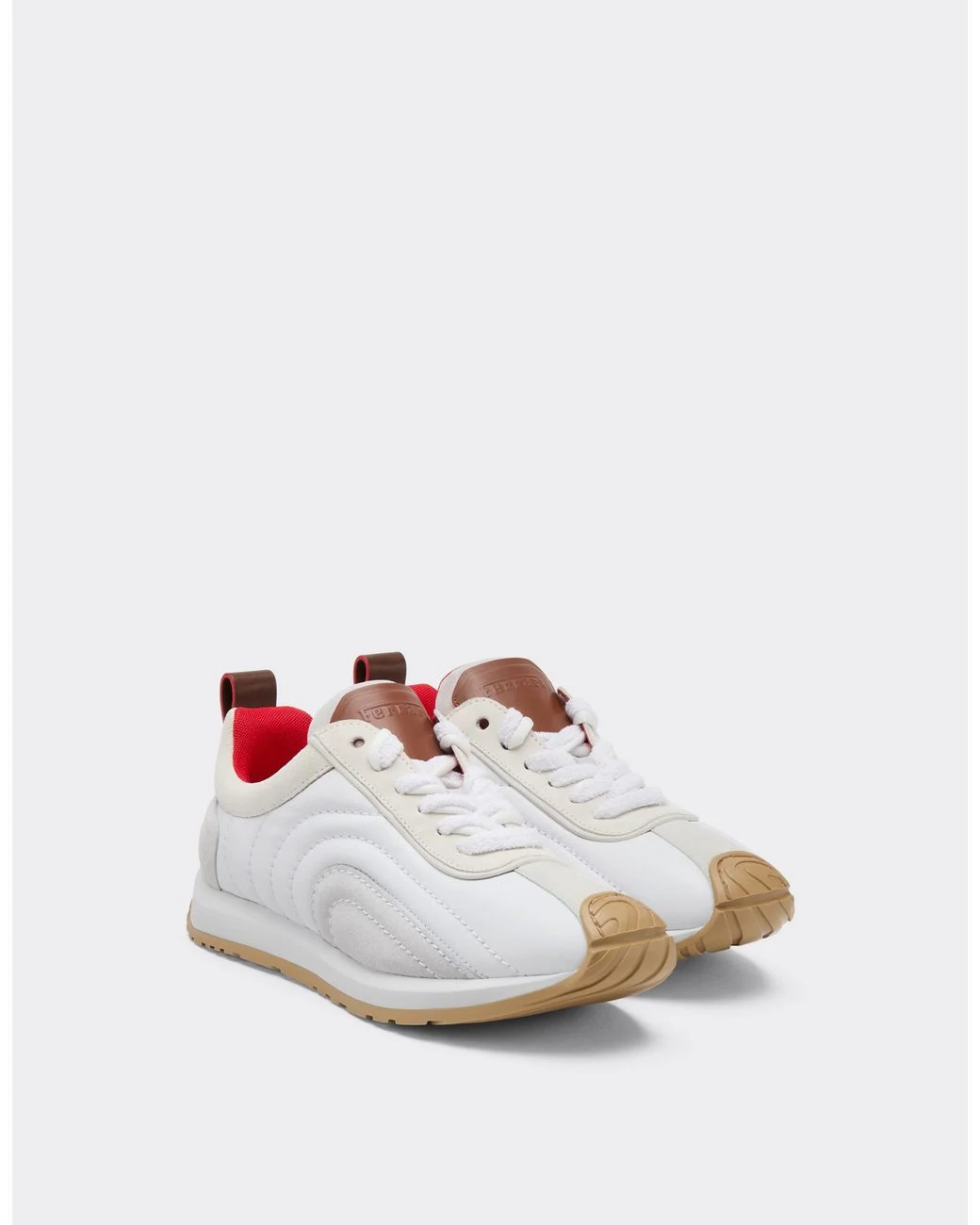 White Ferrari leather and suede running sneakers with sculpted paneling, gum rubber toe guards, tan leather tongue accents, bright red lining, and sporty heritage-inspired styling.