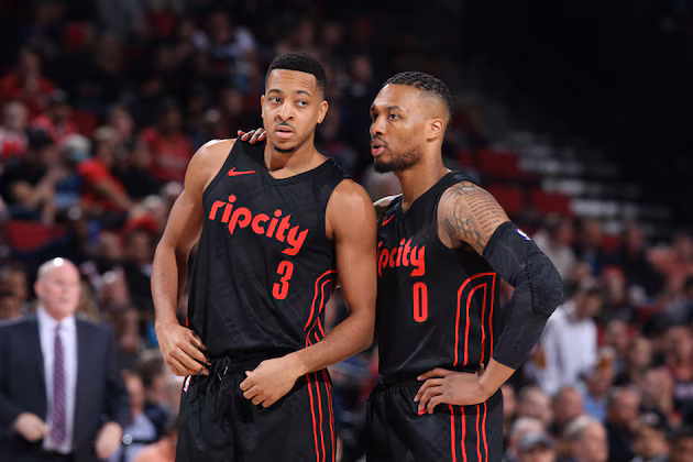 Portland Trail Blazers guards CJ McCollum and Damian Lillard stand together during an NBA game.