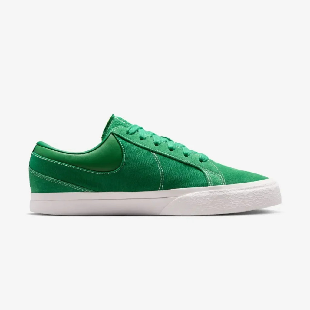 Medial side view of the green Nike low top showcasing the minimalist panel construction, suede overlays, canvas quarter, and crisp white midsole