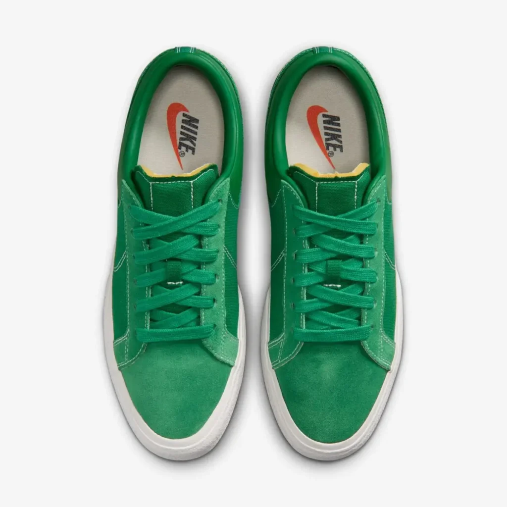 Overhead view of the pair displaying green suede toe boxes, tonal flat laces, exposed foam tongue edges, and Nike-branded insole