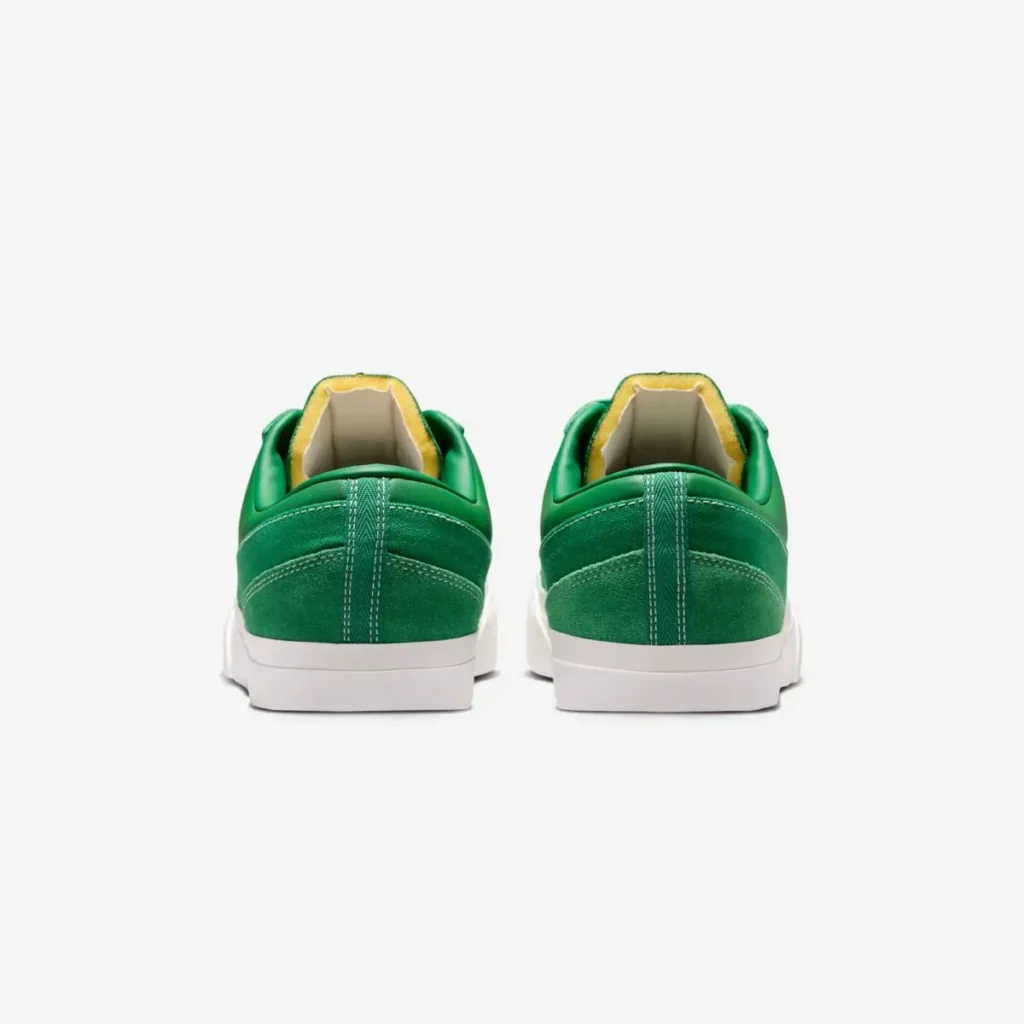 Rear view of the pair emphasizing the suede heel panels, padded collars, vertical heel seam, exposed foam lining, and white vulcanized midsole