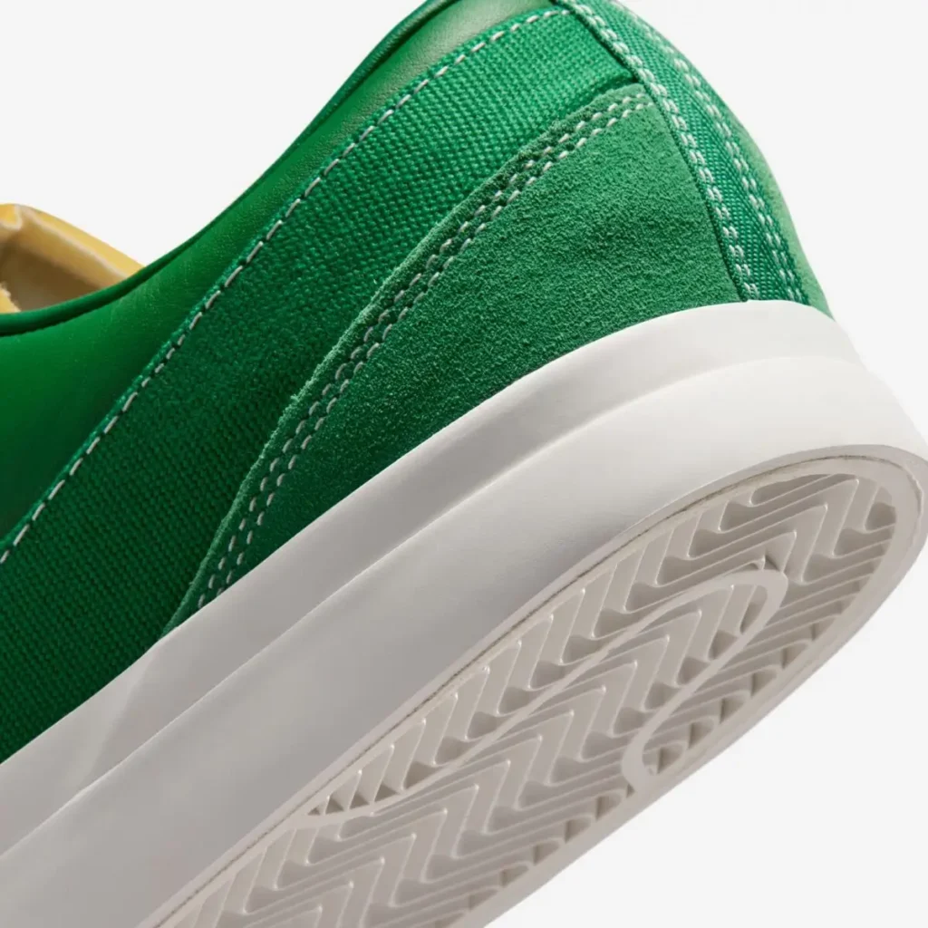 Close-up of the heel highlighting the suede overlay, durable canvas upper, padded leather collar, smooth white midsole, and herringbone rubber outsole