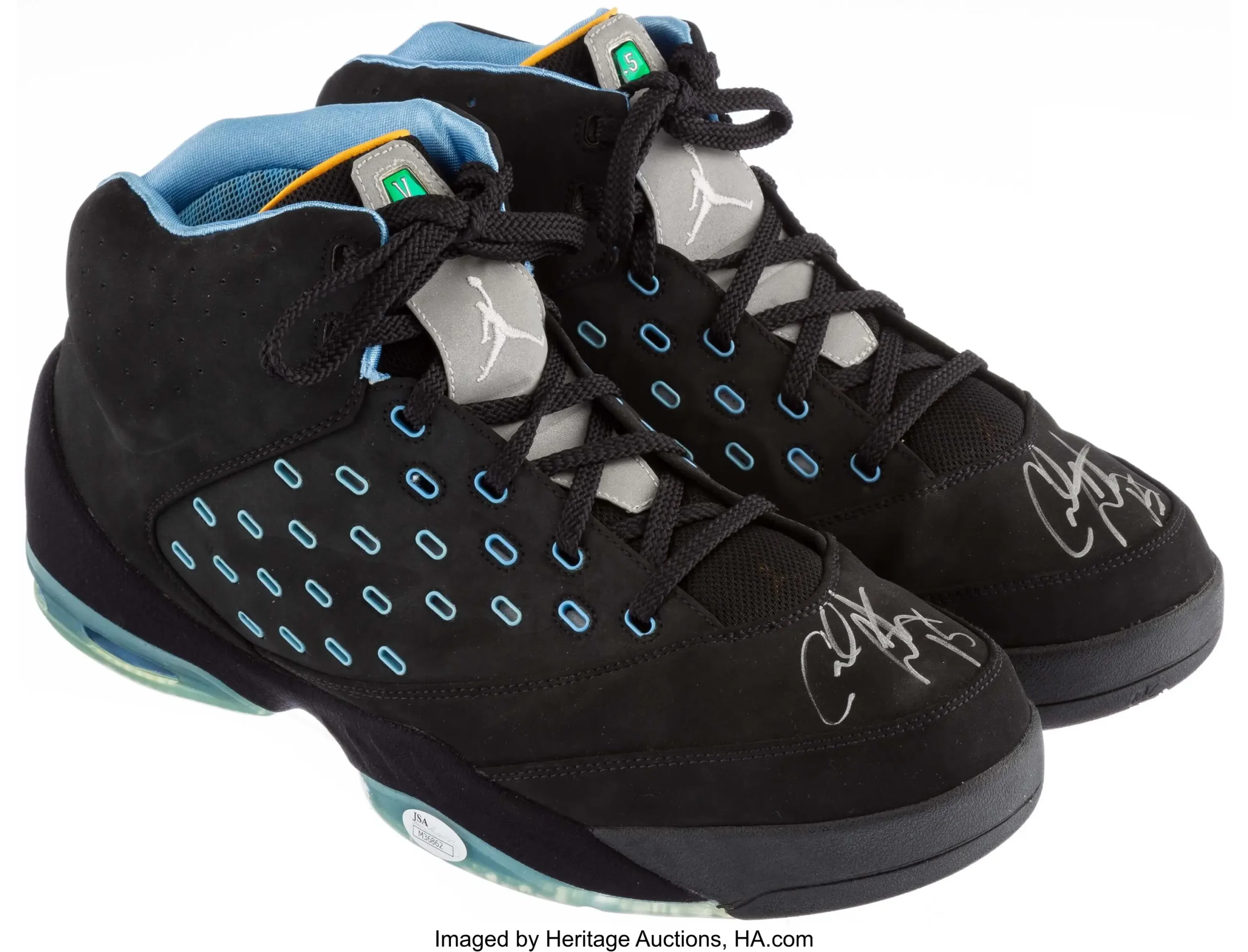 Rear view of a black Jordan Melo basketball shoe featuring powder blue embroidered 'Melo' branding above a gold Jumpman logo, with a translucent icy blue Air cushioning unit, light blue padded collar, and yellow trim against a white background.