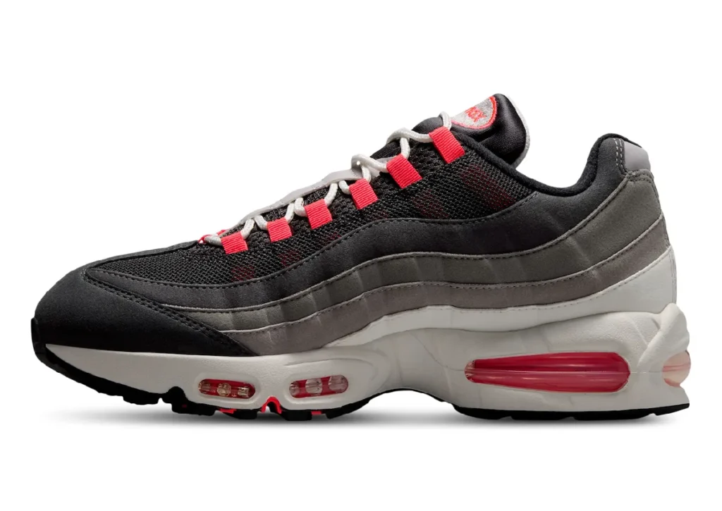Lateral side profile of the Nike Air Max 95 Big Bubble "Solar Red" highlighting the black mesh upper, fading grey suede panels, off-white midsole, oversized Solar Red Air Max unit, and iconic layered design