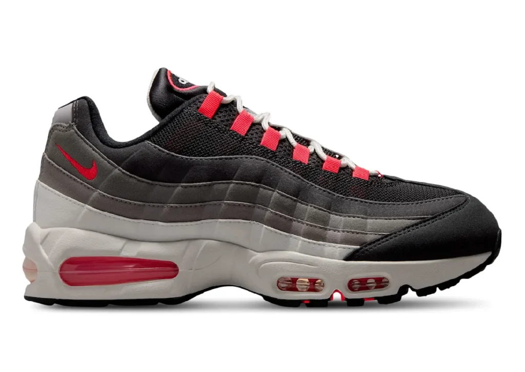 Medial side profile of the Nike Air Max 95 Big Bubble "Solar Red" showcasing the layered gradient grey suede upper, black mesh base, Solar Red accents, oversized visible Air cushioning, and sculpted off-white mid