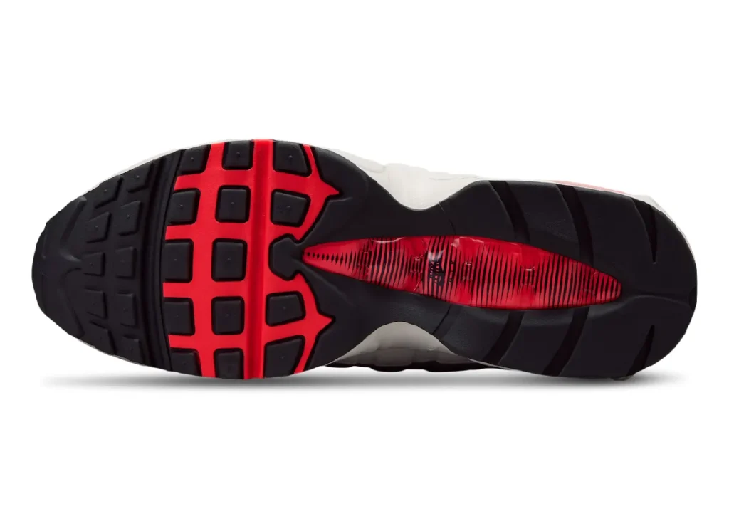 Bottom view of the Nike Air Max 95 Big Bubble "Solar Red" featuring a black rubber outsole with bold Solar Red traction pods, exposed midfoot shank window, and durable waffle-inspired tread pattern