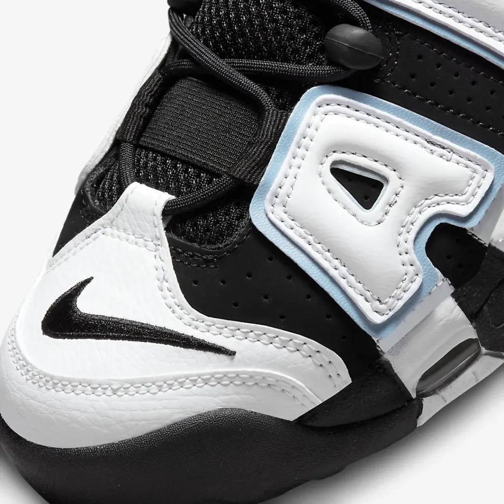 Close-up of the tumbled white leather toe box with embroidered black Nike Swoosh, black mesh tongue, rope laces, and premium stitching detail