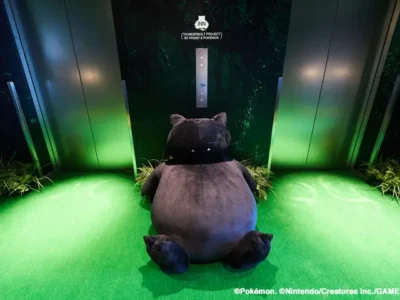 Black Snorlax statue sits in front of a custom THUNDERBOLT PROJECT BY FRGMT & POKÉMON elevator entrance, surrounded by green lighting and indoor landscaping inside sequence MIYASHITA PARK