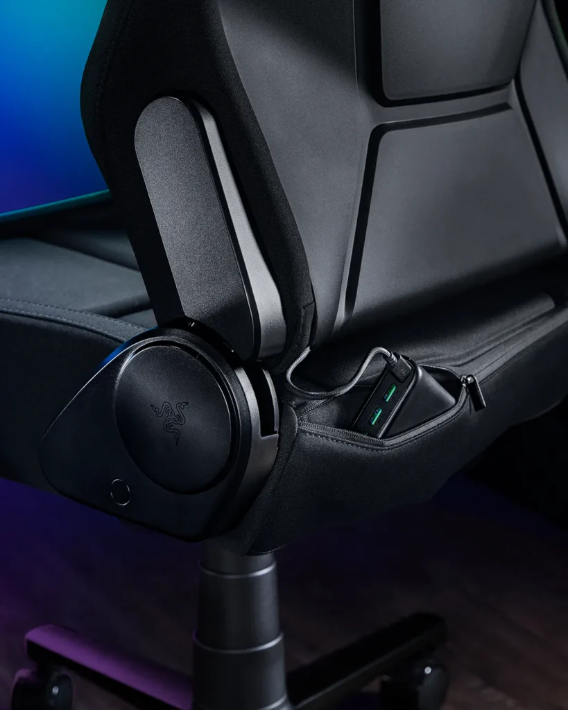 Close-up of the chair's side hinge mechanism with an integrated USB hub concealed inside a zippered compartment beneath the seat