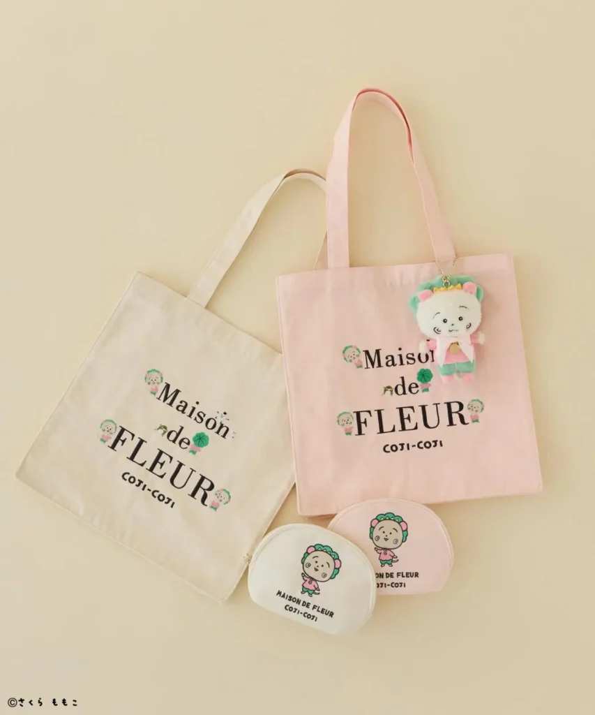 Complete Maison de FLEUR × COTI-COTI collection featuring ivory and pink tote bags, matching embroidered zip pouches, and a pastel plush mascot keychain arranged together on a cream background