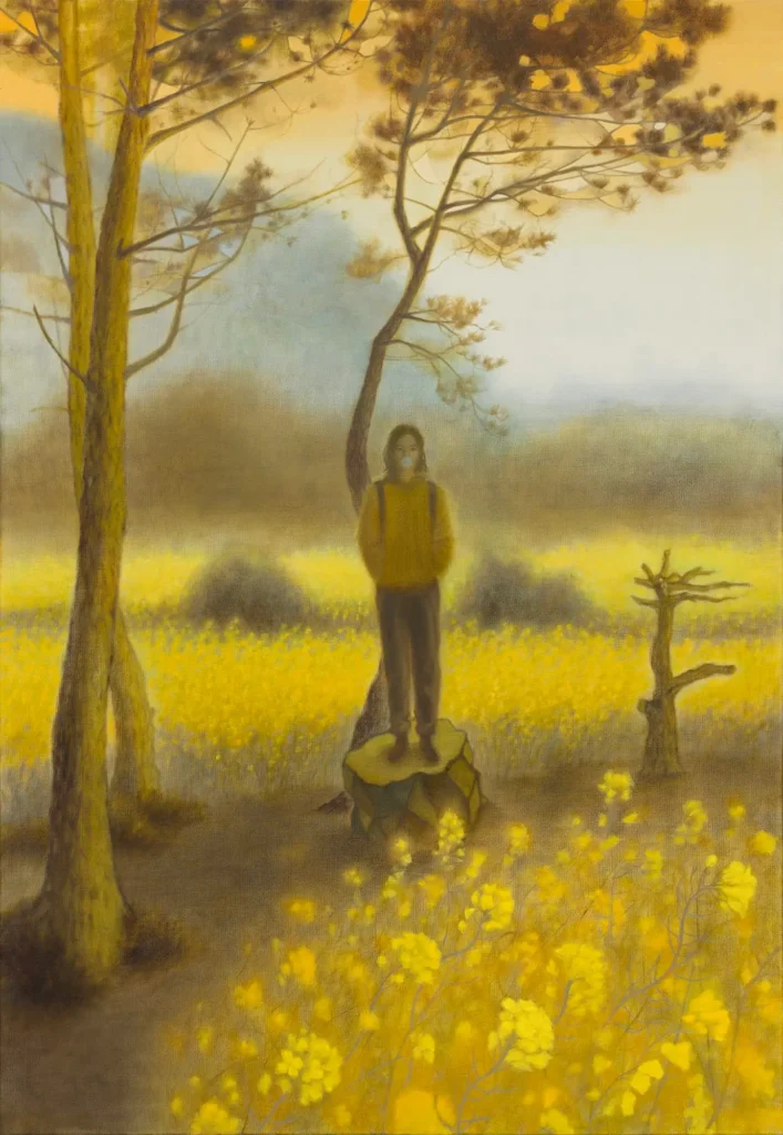 Person standing on a large rock in a golden wildflower field beneath tall pine trees, with a soft misty landscape and warm amber sky creating a tranquil, dreamlike atmosphere