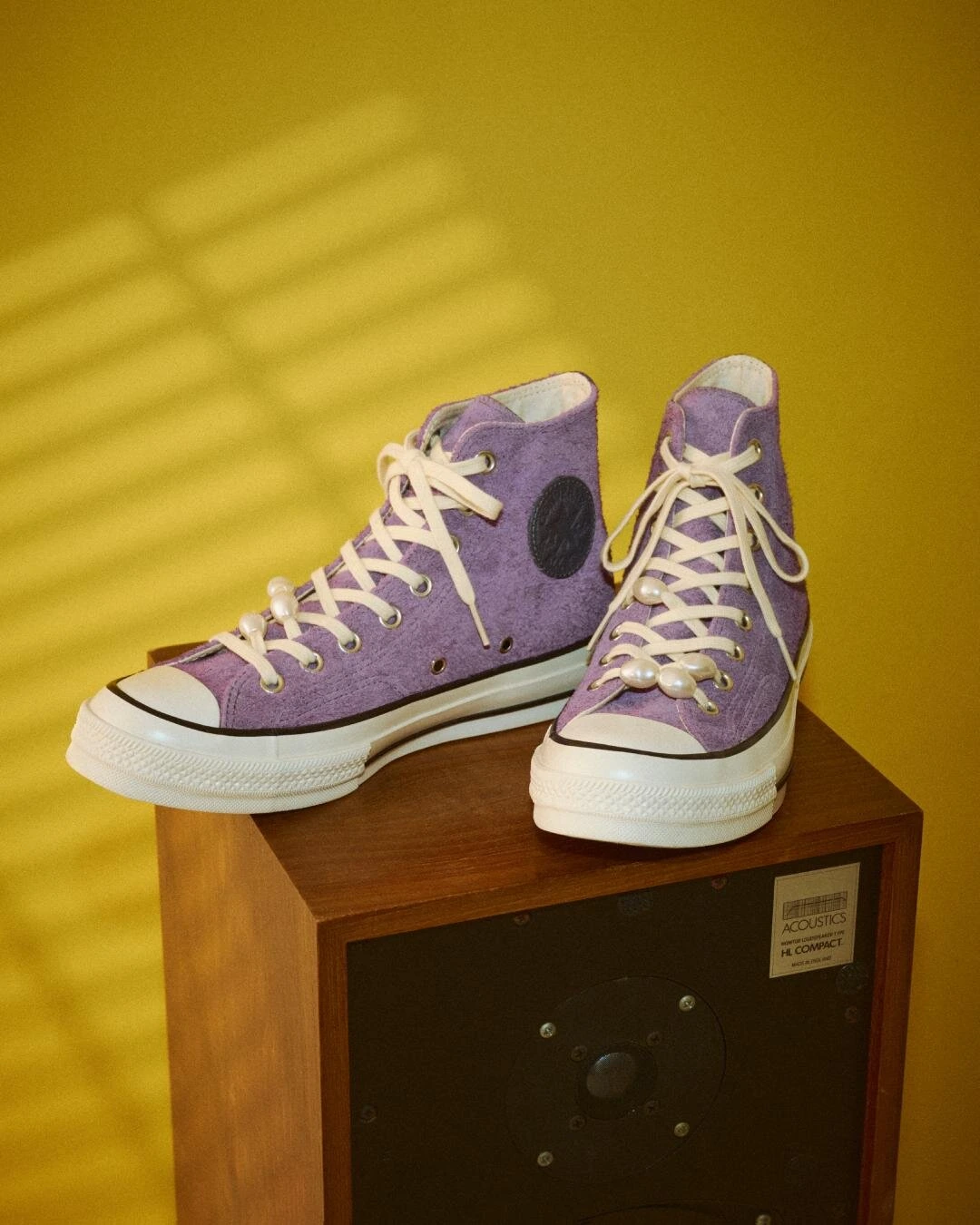 Purple Suede Converse Chuck 70 High-Tops With Pearl-Embellished Laces Displayed On A Vintage Speaker