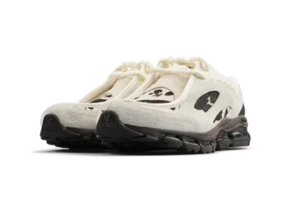 Pair of cream and black cow-print shoes shown from a front three-quarter angle on a white background
