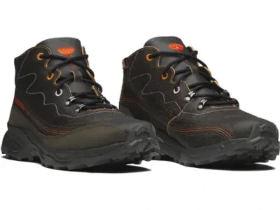 Angle pair shot of black leather Salomon boot feature gray stitch, orange detail, and a rug mid