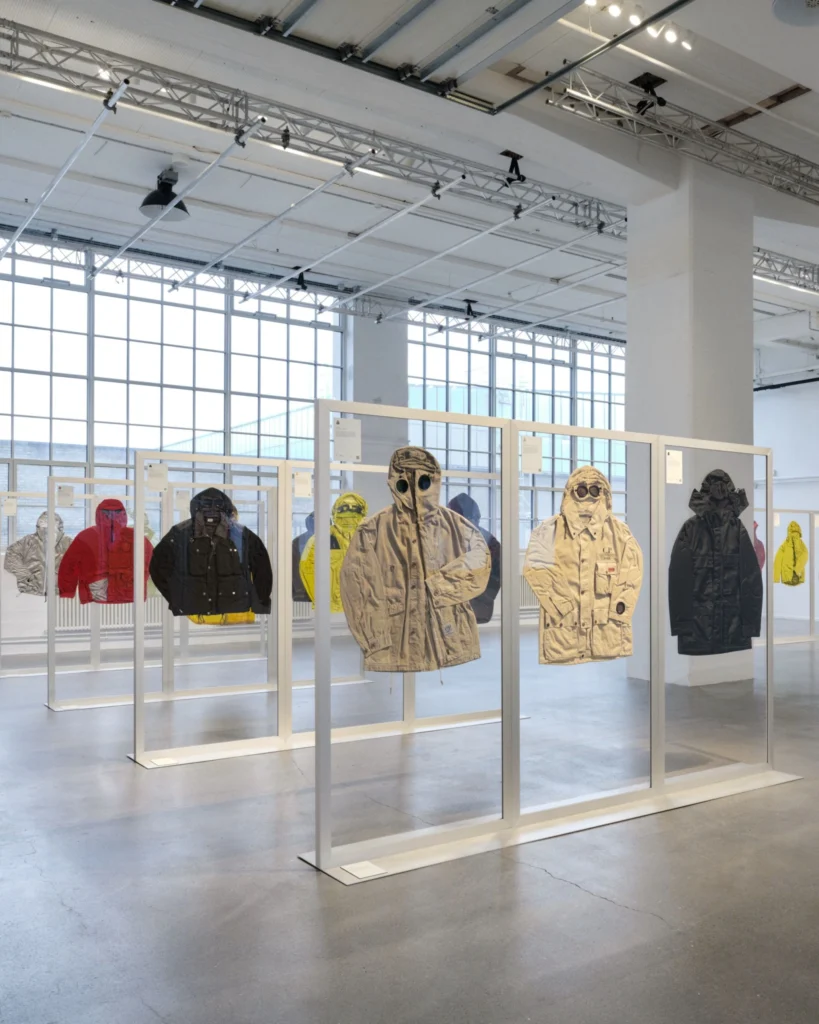 C.P. Company archive jackets display indie set on suspended transparent panels throughout a bright industrial gallery