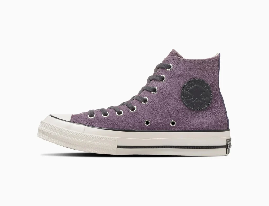 Side View Of A Purple Suede Converse Chuck 70 High-Top With Dark Laces And Black Ankle Patch