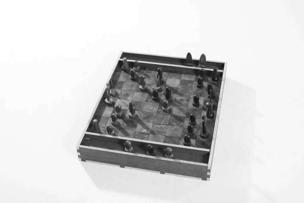 Close-up of a handcrafted wooden chessboard with sculptural abstract pieces arranged across a marbled checkerboard surface