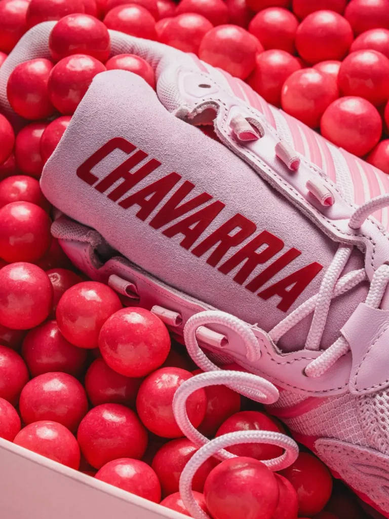 Close-up of the suede tongue with bold red CHAVARRIA branding surrounded by glossy red gumballs and pale pink lace