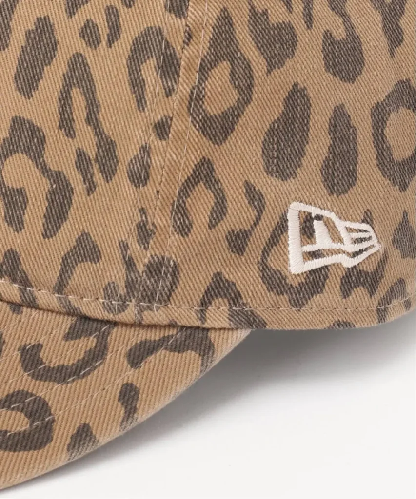 Close-up of a tan leopard-print cap with a white embroidered New Era logo on the side against a white background