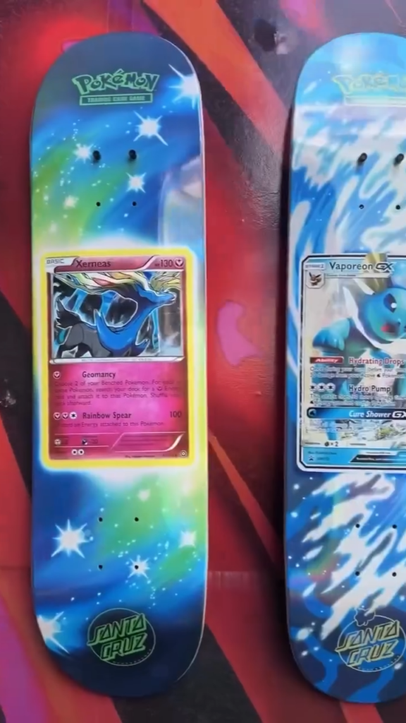 Two Pokémon-themed Santa Cruz skateboards with colorful artwork and visible trading card graphics leaned against a wall