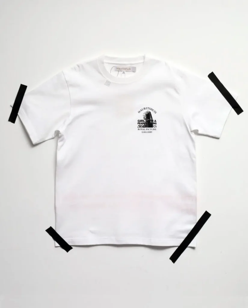 White Tee with a small left chest graphic featuring Girl with a Pearl Earring, Mauritshuis branding, and commemorative museum text
