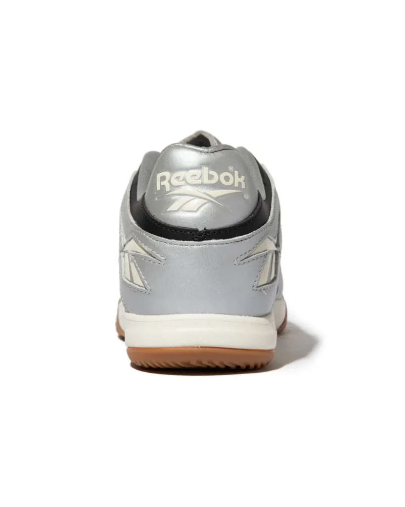 Rear product view of the Reebok Sidewinder 96 ID highlight the metallic silver heel, cream Reebok brand, black trim and gum outsole