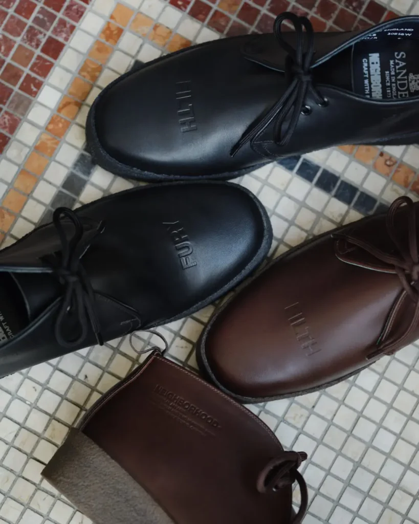 Black and brown leather FURY lace-up shoes arranged on a multi tincture mosaic tile floor