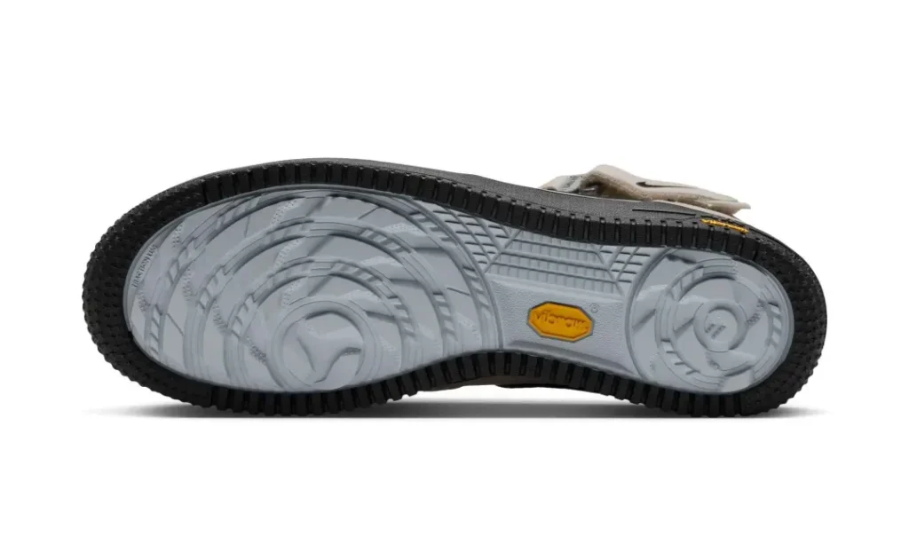 Bottom view of the beige Nike Air Force 1 Mid show a gray and black Vibram tract outsole