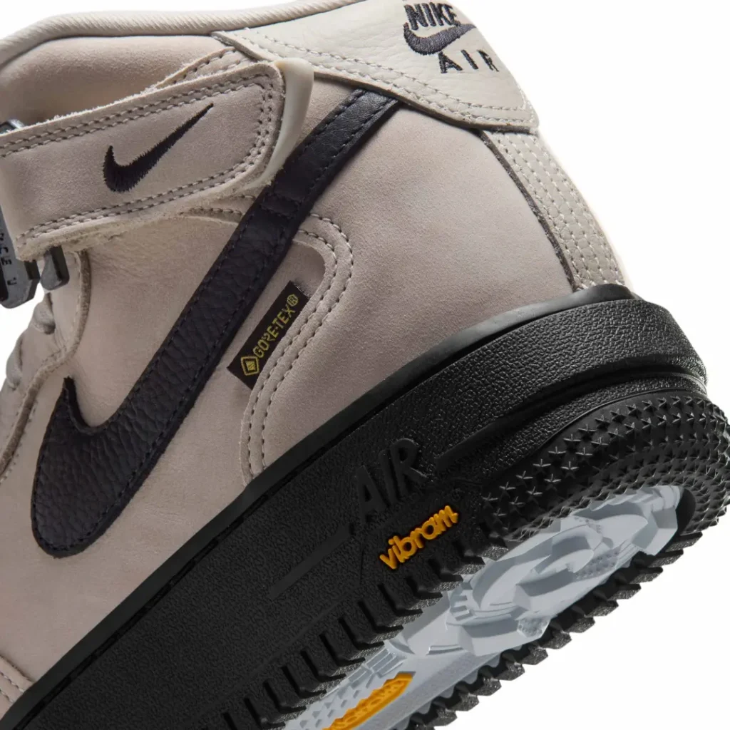 Close-up of the beige Nike Air Force 1 Mid heel show the black Swoosh, GORE-TEX label and Vibram-brand outsole
