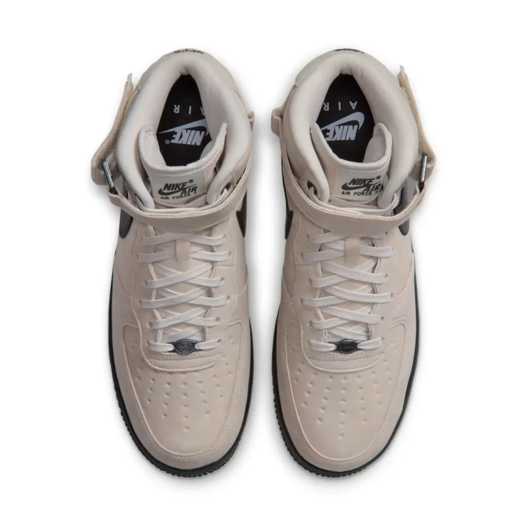 Top view of a pair of beige Nike Air Force 1 Mid shoe show padcollars, ankle strap and tonal lace