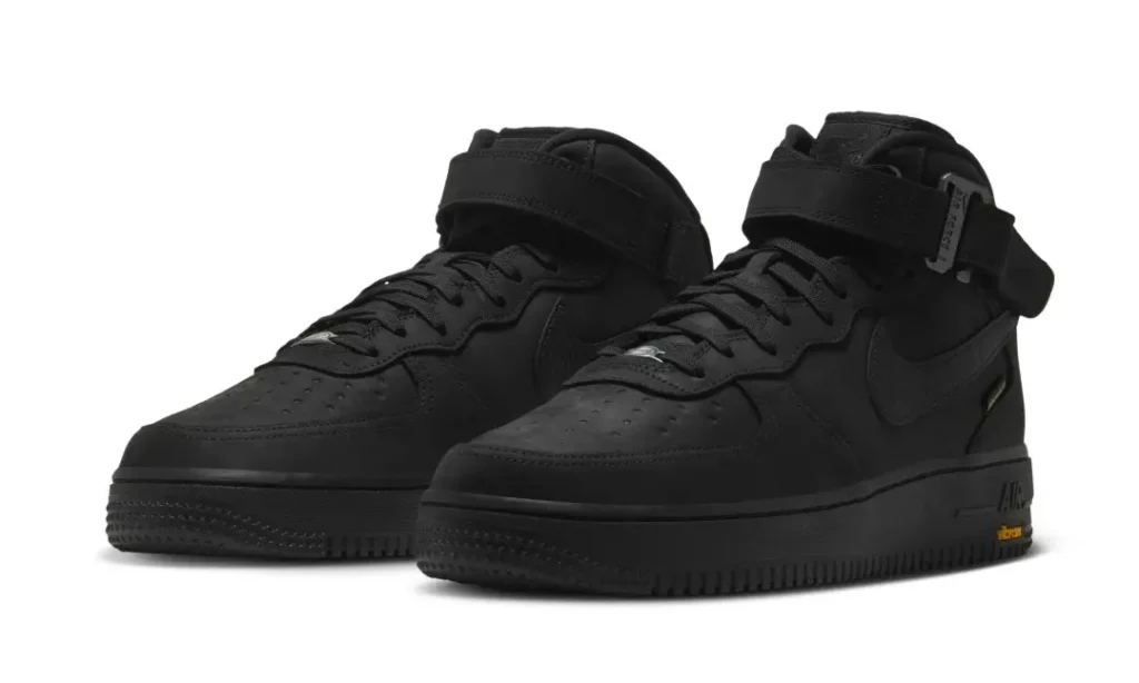 Pair of black Nike Air Force 1 Mid shoe with ankle strap, GORE-TEX construction and Vibram outsole on a white background
