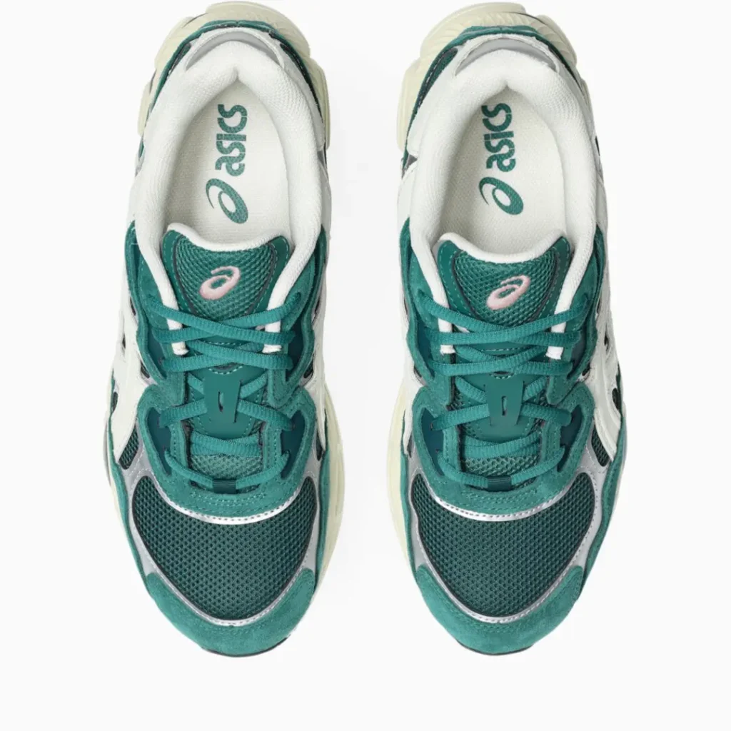 Top view of matching teal and white Asics sneakers with pink logos, laces, mesh panels, and cream soles on white background