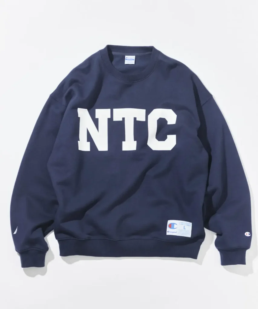 Navy Champion x Nautica crewneck sweatshirt feature an oversize white NTC chest graphic, rib trim, and collide hem label