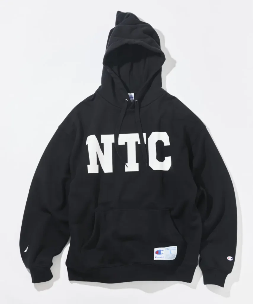 Black Champion x Nautica pullover hoodie feature an oversize white NTC chest graphic, kangaroo pocket, and collide brand detail
