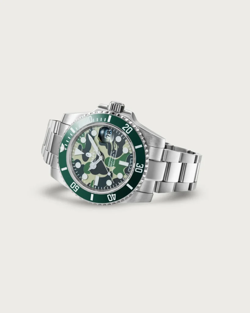 Angled view of the green BAPEX watch highlighting its camouflage dial, green bezel, and steel bracelet
