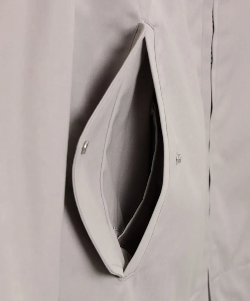 Close-up of the flap hand pocket opened to reveal the pocket interior and snap-button closure