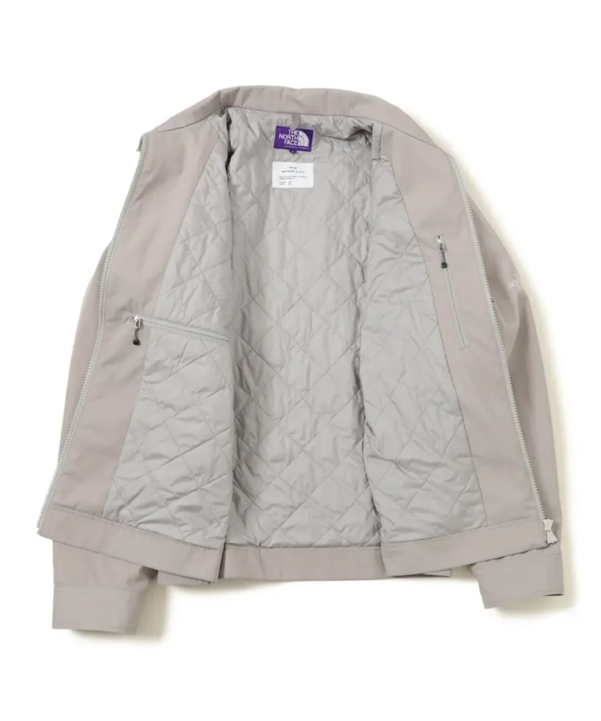 Interior view of the light beige jacket display diamond-quilted lining, dual internal zip pockets, and the Purple Label brand at the neck