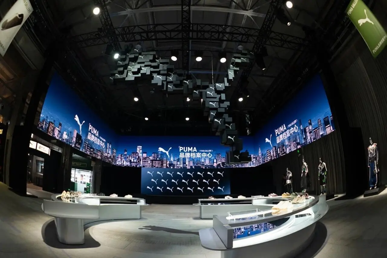 Puma Gallery Interior With Curved Footwear Displays And Cityscape Screens